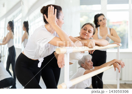 Women students of ballet studio chat sweetly during break, after end of workout. 143050306