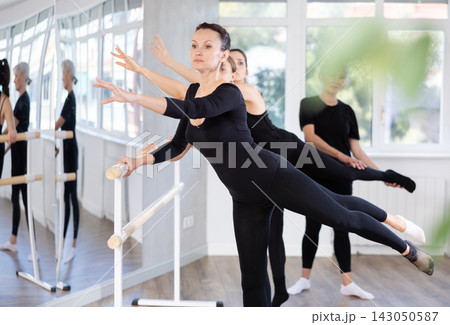 Elderly woman teacher corrects female dancers Elderly woman teacher corrects female dancers 143050587