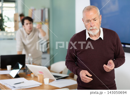 Outraged senior man turned his back on angry and shouting man boss. 143050694