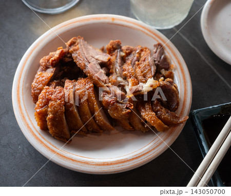 Appetizing pieces of baked duck breast are served with spicy sauce and decorated with white sesame seeds 143050700