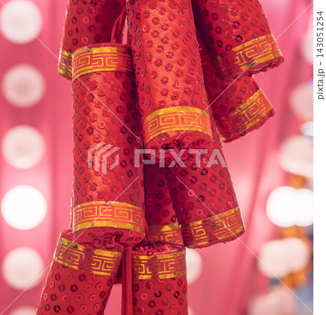 Decorative red firecrackers with shining sequins and gold bands for a vibrant holiday celebration Decorative red firecrackers with shining sequins and gold bands for a vibrant holiday celebration 143051254