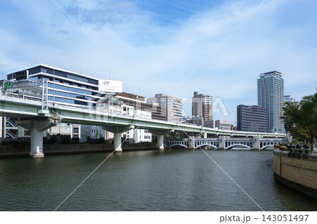 車が行き交う大通りと近代的な高層ビルが立ち並ぶ活気ある都市の街道風景 車が行き交う大通りと近代的な高層ビルが立ち並ぶ活気ある都市の街道風景 143051497