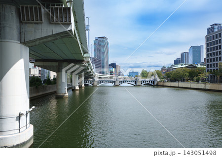 車が行き交う大通りと近代的な高層ビルが立ち並ぶ活気ある都市の街道風景 車が行き交う大通りと近代的な高層ビルが立ち並ぶ活気ある都市の街道風景 143051498