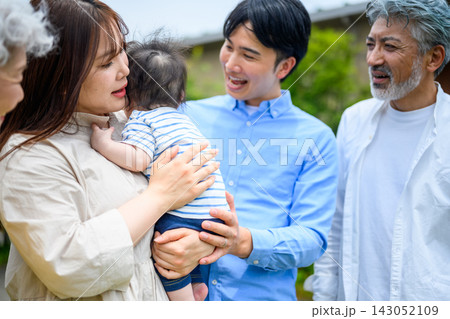 赤ちゃんを囲んで笑顔で見守る家族 赤ちゃんを囲んで笑顔で見守る家族 143052109