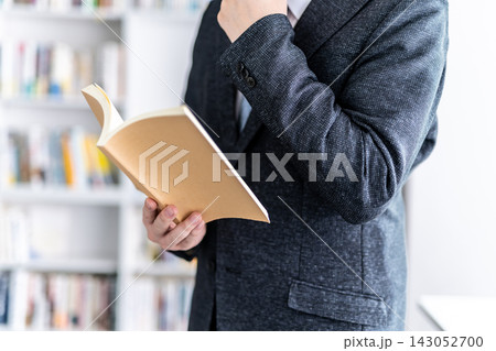 男性が本を読みながら考え込む姿 143052700