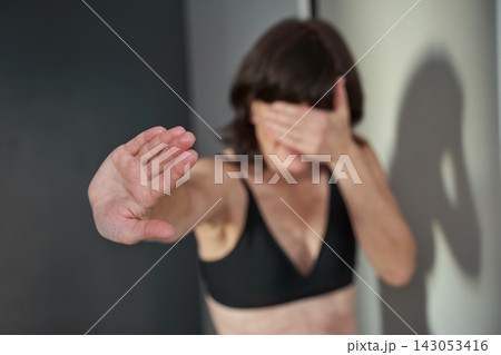 Middle-Aged Woman Reaching Out With Palm Extended And Covering Face In Motion Blur Inside Neutral Middle-Aged Woman Reaching Out With Palm Extended And Covering Face In Motion Blur Inside Neutral 143053416