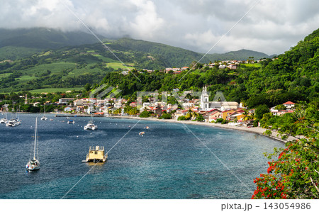 Beautiful view of Saint Pierre bay with boats anchored on the water, the historic town, and lush green hills in Martinique 143054986