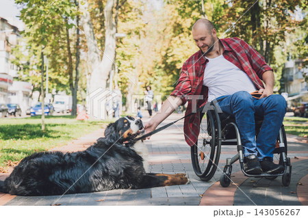 Happy young man with a physical disability in a wheelchair with his dog. 143056267