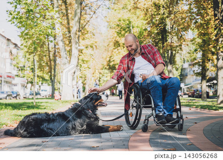 Happy young man with a physical disability in a wheelchair with his dog. 143056268