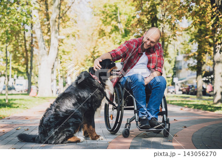 Happy young man with a physical disability in a wheelchair with his dog. Happy young man with a physical disability in a wheelchair with his dog. 143056270