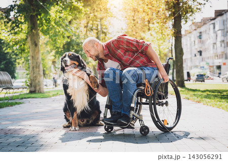 Happy young man with a physical disability in a wheelchair with his dog. Happy young man with a physical disability in a wheelchair with his dog. 143056291