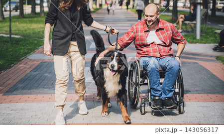 Happy young man with a physical disability in a wheelchair with his dog. 143056317