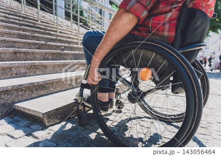 Young man with a physical disability in a wheelchair in front of the stairs Young man with a physical disability in a wheelchair in front of the stairs 143056464