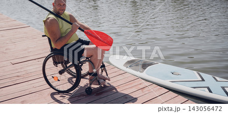 Person with a physical disability in a wheelchair will be ride on sup board Person with a physical disability in a wheelchair will be ride on sup board 143056472
