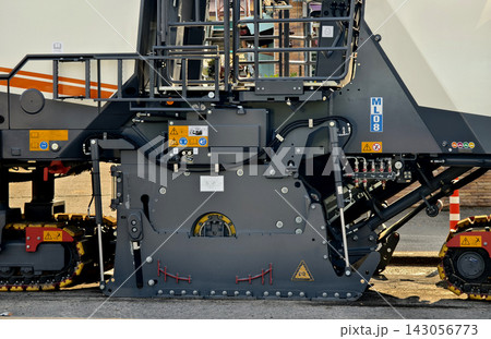 Road paving machine laying fresh asphalt on urban street during clear daylight Road paving machine laying fresh asphalt on urban street during clear daylight 143056773