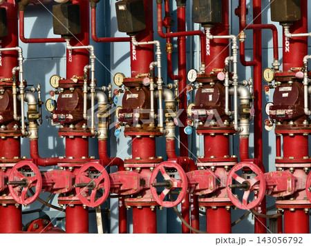 Industrial fire suppression valve assembly with red piping, pressure gauges, brass fittings 143056792