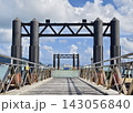 Pier with metal railings leading toward steel ferry jetty over turquoise harbor 143056840