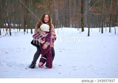 Winter walk.Mother and daughter in snowy recreation forest park Winter walk.Mother and daughter in snowy recreation forest park 143057937