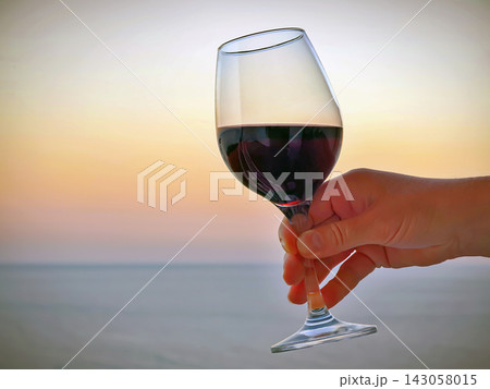 Enjoying red wine at sunset by the sea 143058015
