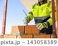 Construction worker applying mortar with trowel on brick 143058389