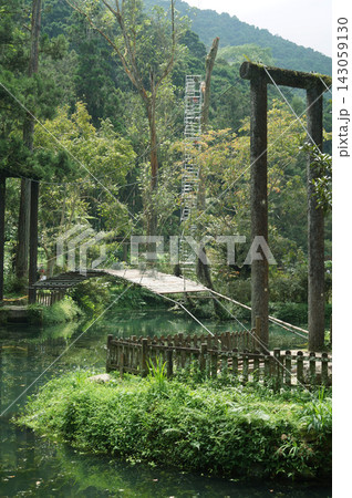 The serene garden landscape with a small arched bridge over a pond in Fengqihu, Taiwan 143059130