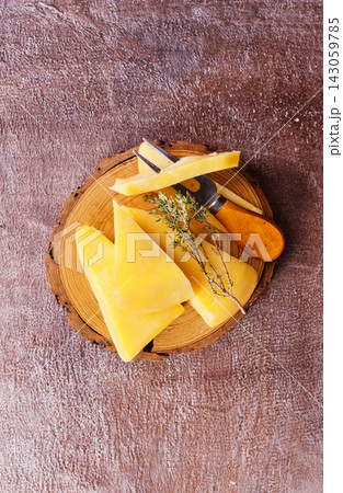 Plate and board with pieces of Swiss cheese on a table Plate and board with pieces of Swiss cheese on a table 143059785
