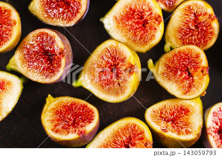 Many figs cut in halves on wooden background 143059793