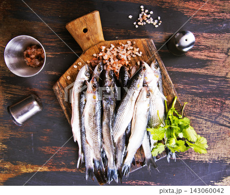 small fish for cooking on wooden board small fish for cooking on wooden board 143060042