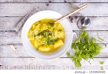 Bowls of potato soup with fresh greens 143060080