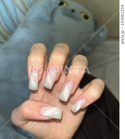 An elegant manicure featuring a nude gradient on long, square-shaped nails. The soft transition from a natural color at the base An elegant manicure featuring a nude gradient on long, square-shaped nails. The soft transition from a natural color at the base 143061354