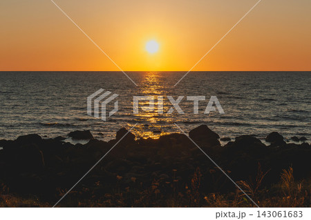 夕陽の光が海面に反射する夕景_オレンジ色のグラデーションの空 夕陽の光が海面に反射する夕景_オレンジ色のグラデーションの空 143061683