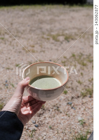 外で楽しむ抹茶と抹茶碗を持つ手 143062877