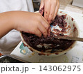 子どもの手で小豆あんとご飯を混ぜておはぎを作る体験 143062975