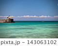 南国のグラデーションブルーの海と赤い屋根の東屋 143063102