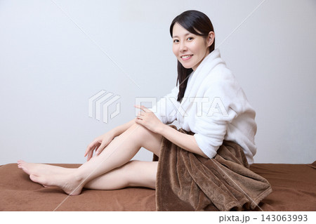 美容サロンで脱毛後の美しい脚を見せる笑顔の女性 143063993