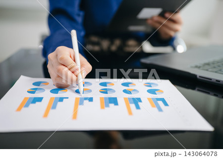 Confident businessman working on laptop, tablet and smartphone at her workplace at modern office. Confident businessman working on laptop, tablet and smartphone at her workplace at modern office. 143064078