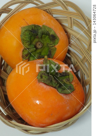 縦構図で籐かごの二個の完熟柿を大きく写した接写写真として使える高解像度素材 縦構図で籐かごの二個の完熟柿を大きく写した接写写真として使える高解像度素材 143064728