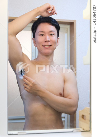 鏡を見ながら脇毛を剃る男性 鏡を見ながら脇毛を剃る男性 143064787