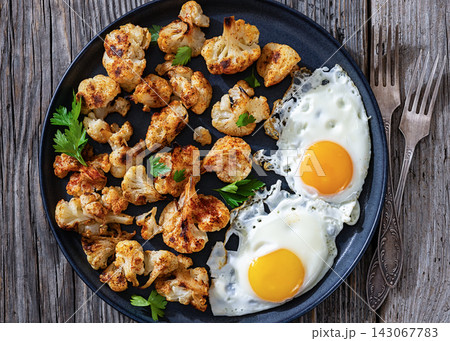 Baked crispy cauliflower served with  fried eggs 143067783