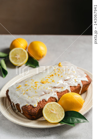 Lemon loaf cake with icing with fresh lemons, lifestyle food background Lemon loaf cake with icing with fresh lemons, lifestyle food background 143067941