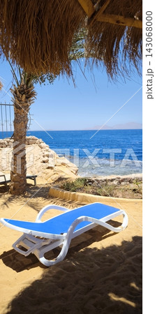 White sun lounger on the sandy beach with a view of the azure sea White sun lounger on the sandy beach with a view of the azure sea 143068000