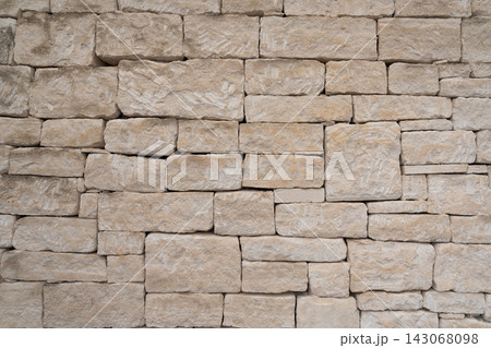 Weathered limestone wall built from rough hand cut stone blocks 143068098