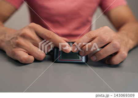 User hands preparing to charge electronic device batteries, unboxing camera power adapter, placing charger on grey table, offering continuous power solution for photography equipment. User hands preparing to charge electronic device batteries, unboxing camera power adapter, placing charger on grey table, offering continuous power solution for photography equipment. 143069309