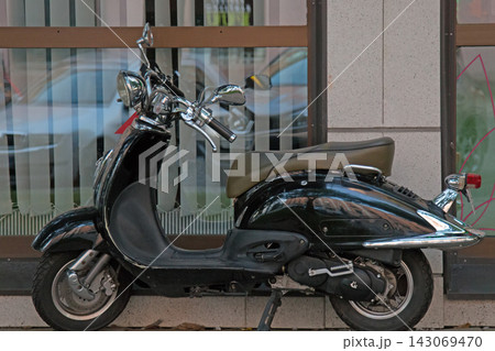 The scooter is parked at the shop The scooter is parked at the shop 143069470