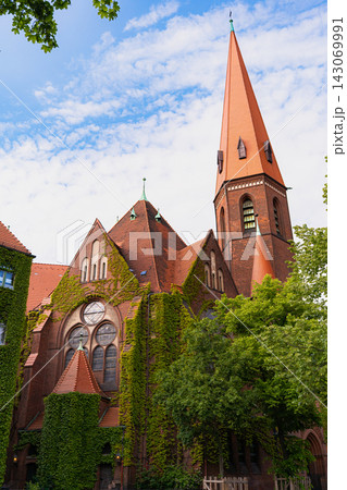 Tall Historic Church Tower Above Ivy Covered Brick Facade Tall Historic Church Tower Above Ivy Covered Brick Facade 143069991