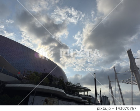 Kai Tak Sports Park main stadium architecture with sunburst and dramatic sky 143070767