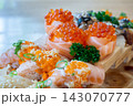 Set of salmon rolls topped with caviar and burned salmon sushi on a wooden tray in japanese restaurant. Japanese food. 143070777