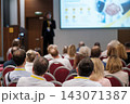 Conference presentation with a handshake image on screen 143071387