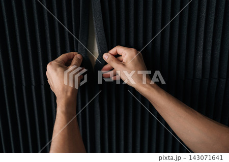 Hands carefully arranging black acoustic foam panels, creating a sound diffused wall surface for optimal audio quality in a recording studio, podcast room, or home setup. Hands carefully arranging black acoustic foam panels, creating a sound diffused wall surface for optimal audio quality in a recording studio, podcast room, or home setup. 143071641