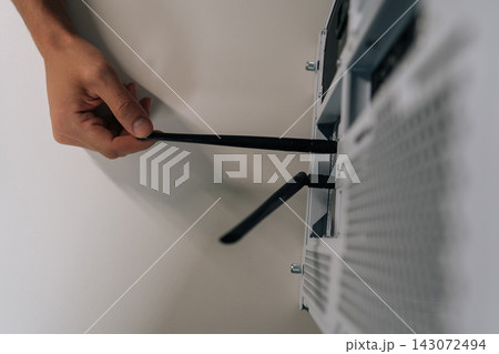 Close-up top view of technician hand installing network antenna into desktop computer, establishing wireless internet connection for device and enabling high-speed data transfer. Close-up top view of technician hand installing network antenna into desktop computer, establishing wireless internet connection for device and enabling high-speed data transfer. 143072494